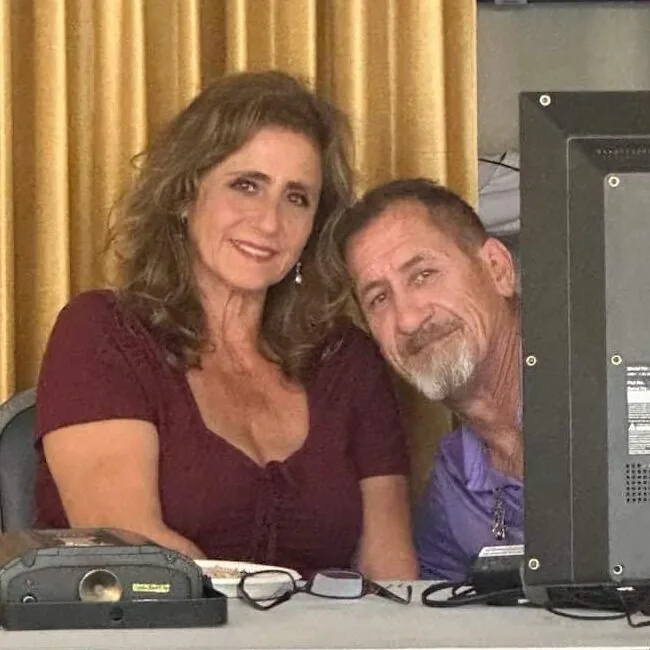Two people at a podcast desk with microphones.