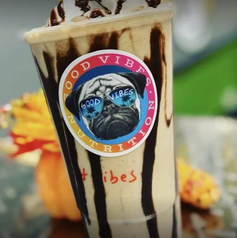 A creamy shake drizzled with chocolate, with the pug-in-sunglasses Good Vibes sticker on the cup.